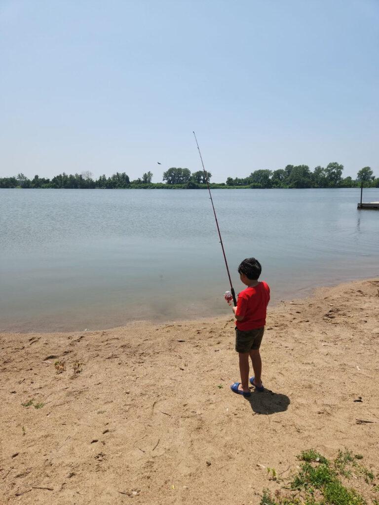 Young man fishing for the first time with fishing rod provided by Susan Harris from Hair Saloon